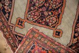 Tattered woven side and fine knot detail on the folded corner of an antique Persian Malayer rug.