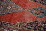 Cherry red abrashed field of Antique Halvai Bijar, with stepped aubergine spandrel and floral patterns.