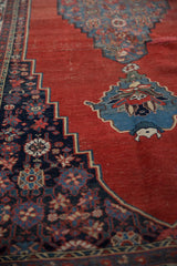 Stepped contour of antique Halvai Bijar with cherry red field and navy floral border.