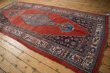 Antique Halvai Bijar runner corner: ruby red field, navy spandrel, stylized floral, bird motifs.