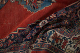 Antique Halvai Bijar rug corner detail: navy border, ruby red field, and beige spandrel.