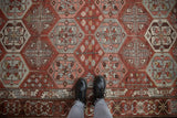 Overhead perspective showing the scale and texture of a distressed Baktiari rug with geometric patterns.