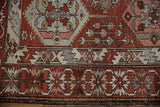 Corner detail of a distressed Baktiari rug showing the serrated leaf border in chestnut and silver.