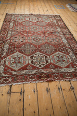 Low angle view of a vintage Baktiari rug showing the distressed low pile and geometric pattern.