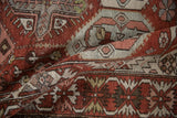 Low-pile texture and serrated leaf details on a folded section of a vintage distressed Baktiari rug.