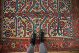 A person's view of the intricate, hand-knotted pile of a fine antique Malayer rug.