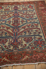 Detailed side view of an antique Malayer rug, showing the sprawling serrated leaves and columned vine motifs.