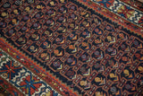 Dark navy field with geometric vinery and boteh lattice, bordered by red and ivory patterns.