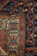 Vintage Kurdish Hamadan rug detail: dark navy field, madder red border, knotted foundation.