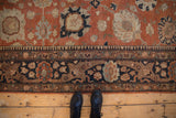 Detail of a vintage Tabriz carpet's worn pile, with palmettes and a charcoal navy floral border.
