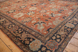 Detailed corner of a vintage Tabriz carpet with rust and navy Safavid-inspired floral designs.