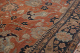 Angled detail of a vintage Tabriz carpet with floral palmettes in rust, charcoal, and dusty blue.