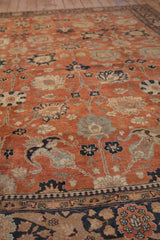 Angled view of a vintage Tabriz shows even wear on the rust and blue floral pile.