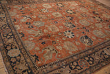 Corner of a vintage Tabriz carpet showing Safavid-inspired floral palmettes in its navy and sand border.
