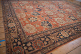 Corner view of a vintage Tabriz rug, showing the detailed navy border and rust floral field.