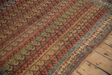 Low pile of an antique Bijar carpet showing its repeating boteh pattern and floral border.