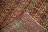 A folded corner on an antique Bijar reveals the dense pile and hand-knotted reverse weave.