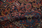 Soft folds of a vintage Persian rug showing the dense texture of its floral and boteh designs.