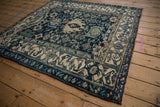 Angled view of a vintage Bijar rug's dense Harshang pattern in dusty navy, teal, and ivory tones.
