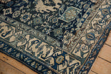 Corner detail of a vintage Persian Bijar rug with geometric motifs in ivory, teal, and navy blue.