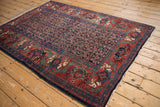 Vintage Bijar rug detail: mythical antlered animals border and navy Herati field.