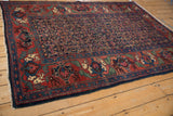 Bijar rug corner with cherry red border, mythical antlered animals, dusty navy Herati field.
