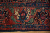 Vintage Persian Bijar rug border displaying mythical antlered animals in cherry red and dusty navy.