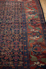 Persian Bijar rug's brick red border with mythical antlered animals and navy Herati field.