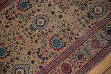 Worn vintage Tabriz runner detail: sand field, blue and red blossoms, striped border.