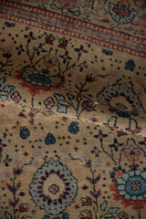 Hand-knotted pile texture of the vintage Tabriz rug, showing sand, blue, and red blossoms.