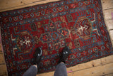 Overhead view of a vintage Karaja rug showing its scale and geometric medallions in red, blue, and ivory.