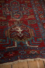 Angled view of a vintage Karaja rug showing worn pile, geometric motifs, and short ivory fringe.