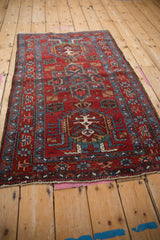 Angled view of a vintage Karaja rug showing its traditional geometric medallions and rich red field.