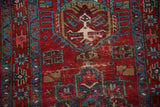 Wear patterns on the vintage Karaja rug's medallion, showing exposed foundation and knot heads.