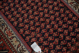 Close-up of the hand-knotted pile showing a minor threadbare spot on a vintage Kurd rug.