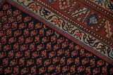 Geometric boteh pattern and serrated leaf border on a vintage hand-knotted Kurd rug.