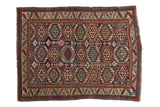 Vintage square Caucasian rug with repeating octagonal guls in navy blue, cherry red, and beige.