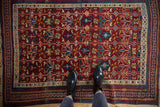 Full overhead view of an antique Caucasian Seichour rug with colorful geometric pinwheel motifs.