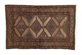 Antique fine Kurd rug with repeating geometric diamond medallions in indigo and copper on an abrashed camel field.