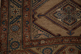 Corner of an antique Kurd rug showing a geometric vine border and even wear across the hand-knotted pile.