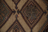 Evenly worn pile of an antique Kurd rug showing detailed geometric medallions in indigo and copper.
