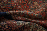 Intricate madder red and navy floral vinery on vintage Farahan Sarouk rug with ivory and jade green.