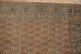 Antique Tabriz rug's intricate terracotta boteh field and navy floral border.