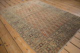 Antique Tabriz rug corner showcasing its vine floral main border and intricate boteh field.