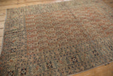 Intricate botehs covering the pale copper field and navy floral border of antique Tabriz rug.