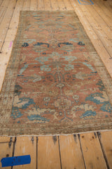 Distressed vintage Malayer rug's field, displaying traditional copper, terracotta, and powder blue arabesque patterns.