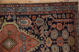 Detail of Vintage Mehriban rug with navy, madder root, dusty blue serrated leaves.