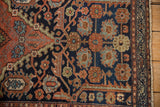 Vintage Mehriban rug: navy field with geometric copper leaves, blue botehs, worn pile, and patterned border.