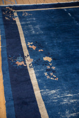 Vintage Peking carpet's indigo field showing wear, cobalt blue, beige borders, and blossoms.