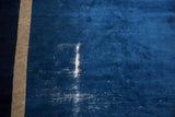 Vintage Peking carpet showing indigo blue pile, wear to foundation, and a beige selvage.